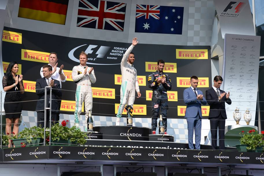 Il podio del Gp d&#39;Ungheria: sul primo gradino Hamilton, a sinistra il secondo classificato Nico Rosberg e a destra sul terzo gradino Daniel Ricciardo. Lapresse